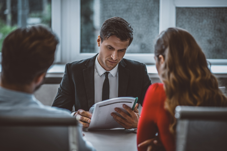 Divorce attorney discussing document with divorced couple